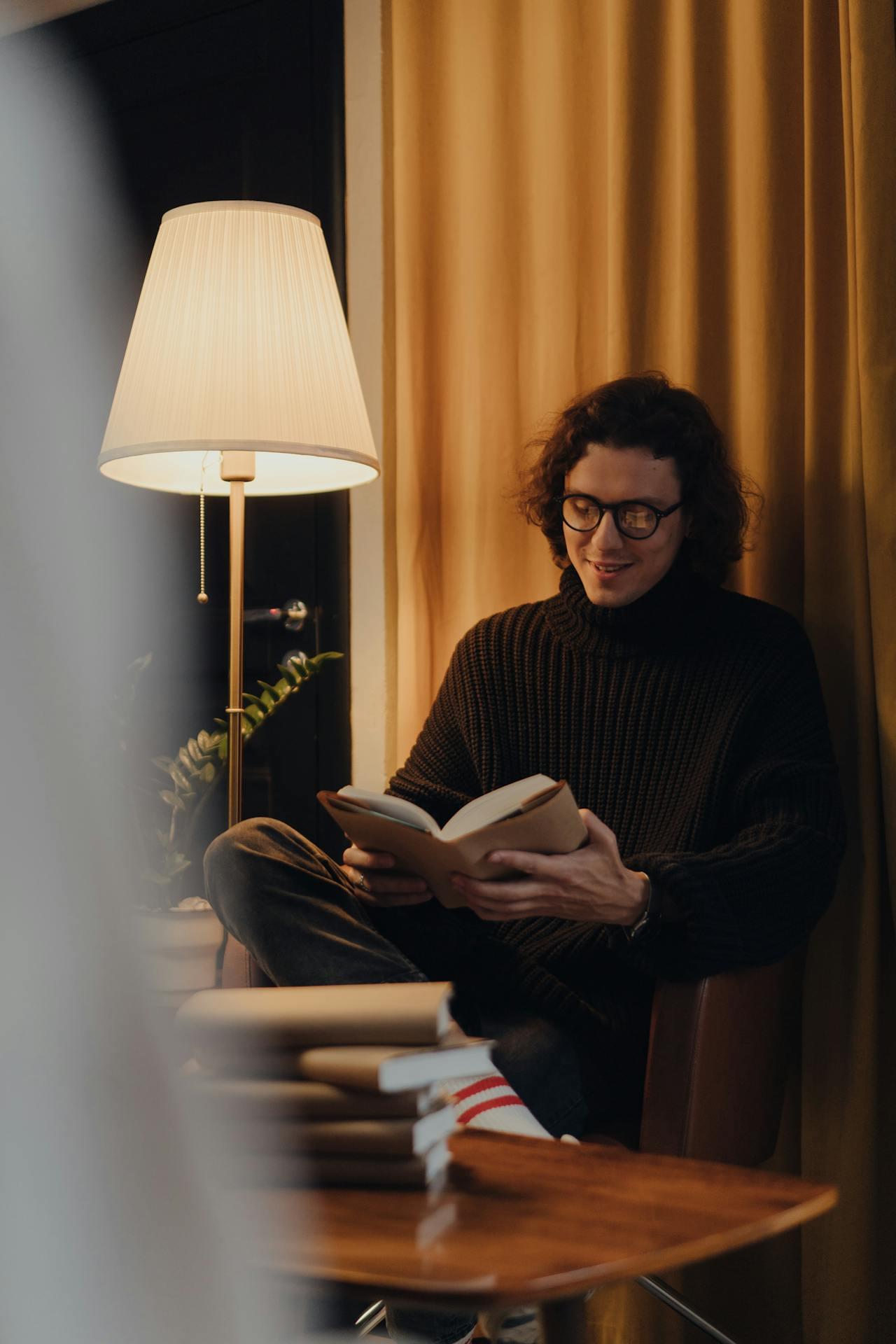 Мужчина читает книгу в уютном кресле